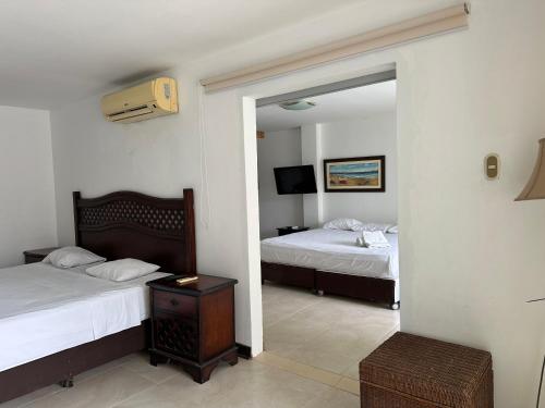 a hotel room with two beds and a mirror at Mango & Apartments in Tumbes