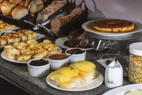 a table topped with plates of pastries and other desserts at Pousada Papaya - Bonito in Bonito