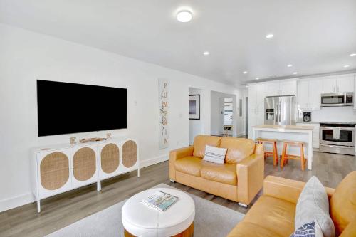 a living room with a couch and a tv on a wall at Orange Dream in the Sky in Fort Lauderdale