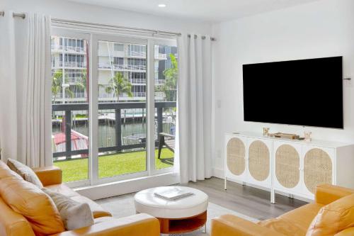 a living room with a tv and a large window at Orange Dream in the Sky in Fort Lauderdale