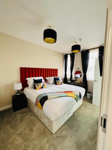 a bedroom with a large bed with a red headboard at The courtyard bar, kitchen, rooms in Falkirk