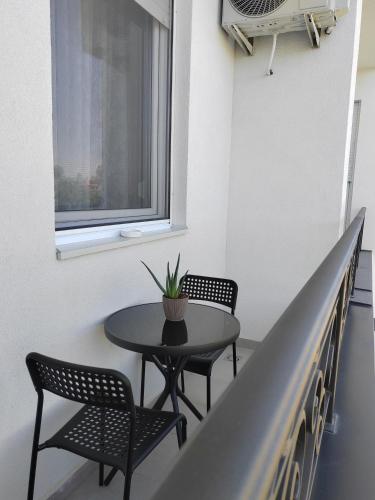 a table and chairs in a room with a window at Apartman Lola Palić II in Palić