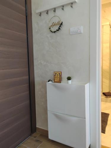 a white refrigerator in a kitchen next to a door at Apartman Lola Palić II in Palić