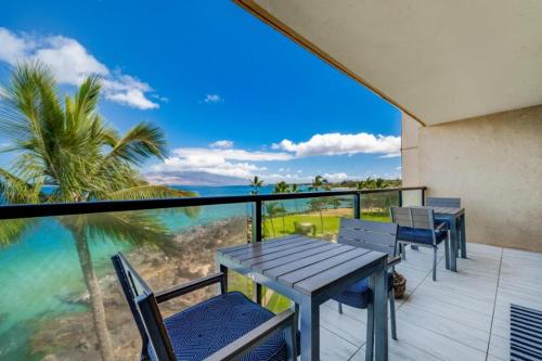 a table and chairs on a balcony with a view of the ocean at KIHEI SURFSIDE, #501 condo in Wailea
