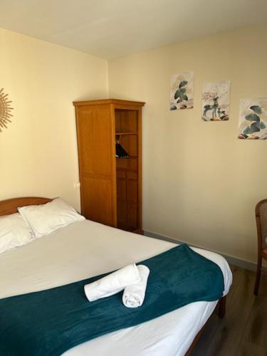 a bedroom with a bed with two towels on it at La cocotte in Soullans