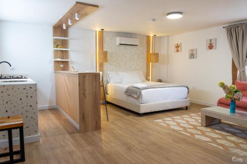 a bedroom with a bed and a living room at Casana Rosa Hotel in Santa Marta