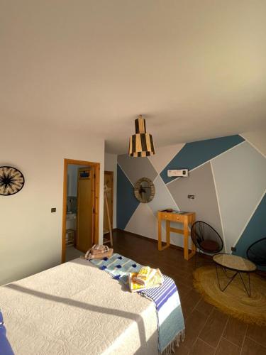 a bedroom with a bed and a clock on the wall at Dar Mouja, eco-friendly home in Imsouane