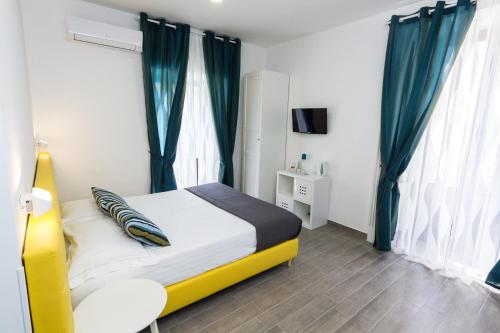 a bedroom with a bed with blue curtains at Etna Suite Group in Catania