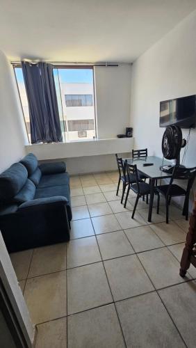 a living room with a couch and a table and chairs at Apartamento na Praia do Forte - Cabo Frio in Cabo Frio