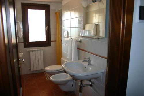 a bathroom with a sink and a toilet and a window at Agriturismo Simonello in Stignano