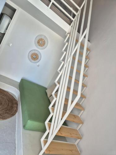 a spiral staircase in a house with a green bench at Koko Room's 2 in Dhriopís