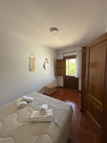 a bedroom with a bed with towels on it at La Casina Del Mercao in Aldeanueva del Camino