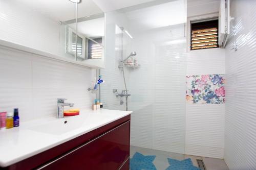 a white bathroom with a shower and a sink at Casa Mimosa Bright and Soulful in Budva