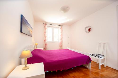 a bedroom with a purple bed and a window at Casa Mimosa Bright and Soulful in Budva