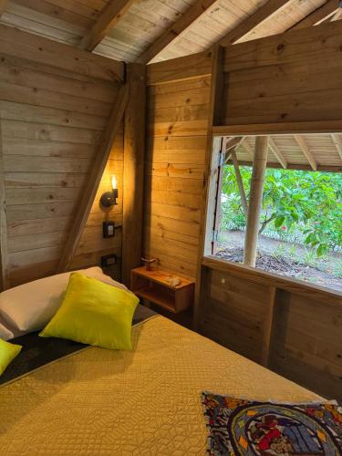 a bedroom with a bed in a room with a window at Madre Selva Eco Lodge in Nuquí
