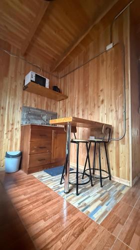 a desk in a room with a wooden wall at Cabañas y tinajas Filkun in Vilcún
