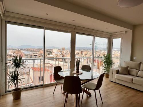 ein Wohnzimmer mit einem Tisch und Stühlen sowie einem großen Fenster in der Unterkunft Recién reformado! Oasis de lujo con vistas panoramicas in Águilas