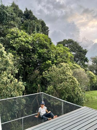 a man sitting on top of a fence at Casa campestre en el Eje Cafetero in Circasia