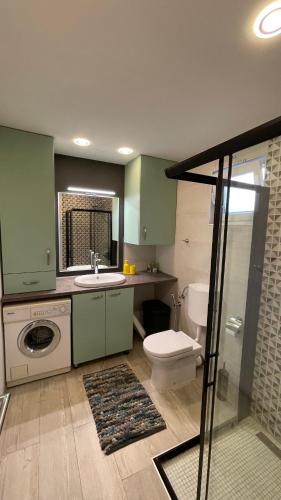 a bathroom with a toilet a sink and a washing machine at MO House Mostar in Kutilivač