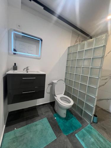 a bathroom with a toilet and a sink at Blue House Lodge in Faaa