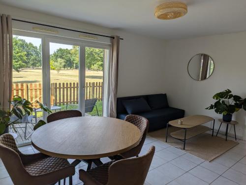 a living room with a table and chairs and a couch at Beau T2 première ligne au Teich, espace nature, accès plage et port in Le Teich
