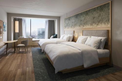 two beds in a hotel room with a large window at The Westin Galleria Dallas in Dallas