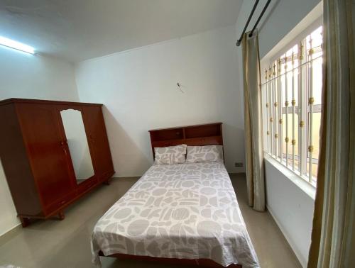 a bedroom with a bed and a dresser and a window at Maison de Pagoda in Port Louis