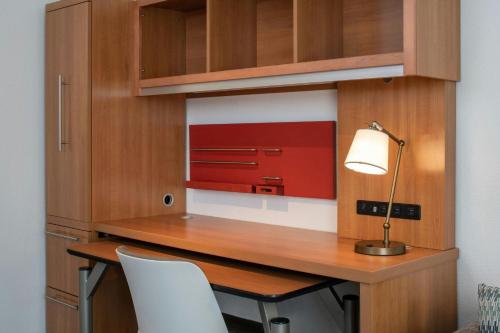 a room with a desk with a lamp and chairs at TownePlace Suites by Marriott Huntsville West/Redstone Gateway in Huntsville
