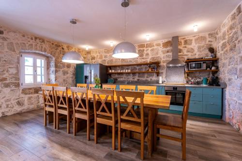 a kitchen and dining room with a wooden table and chairs at Villa Joe in Čilipi