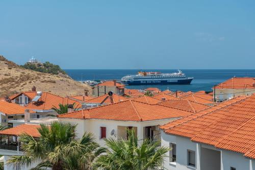 a cruise ship in the water with houses at Alysos Luxurious Apartments in Mirina