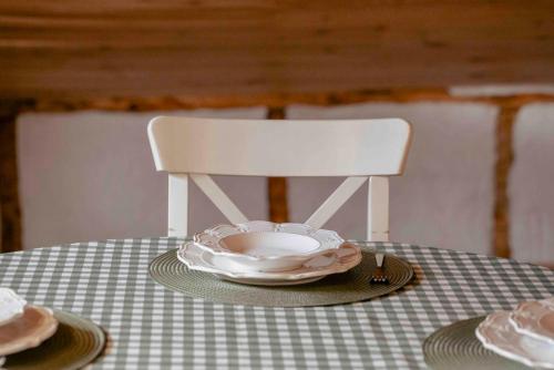 a table with a white chair and plates on it at Suite La Mansion Casa Rural in La Toba