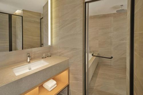 a bathroom with a sink and a shower at Courtyard by Marriott Pyeongtaek in Pyeongtaek