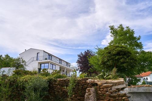 a white house on top of a stone wall at Sky House by Everkind in Viana do Castelo