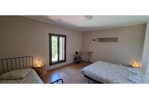 une chambre avec deux lits et une fenêtre dans l'établissement L'intemporelle, à Saint Dionizy