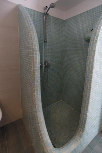 a shower in a bathroom with green tile at Ilioperato Hotel in Imerovigli