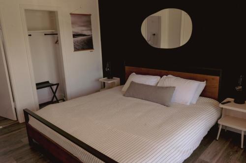 a bedroom with a large bed with a mirror on the wall at The Spinn in Manzanita