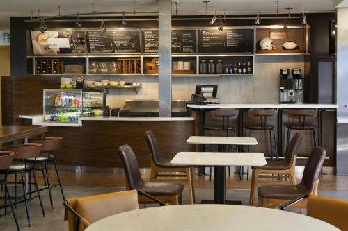 a restaurant with tables and chairs and a bar at Courtyard by Marriott Fresno in Fresno
