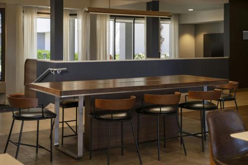 a bar in a restaurant with stools around it at Courtyard by Marriott Fresno in Fresno