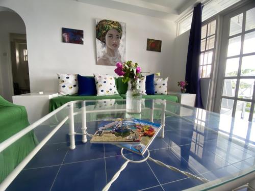 a living room with a glass table and a couch at Le Maison Apartments-Gran Anse in Morne Rouge