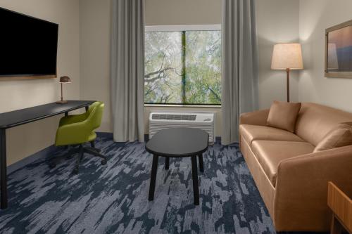a living room with a couch and a desk and a chair at Fairfield by Marriott Inn & Suites Stockton Lathrop in Lathrop