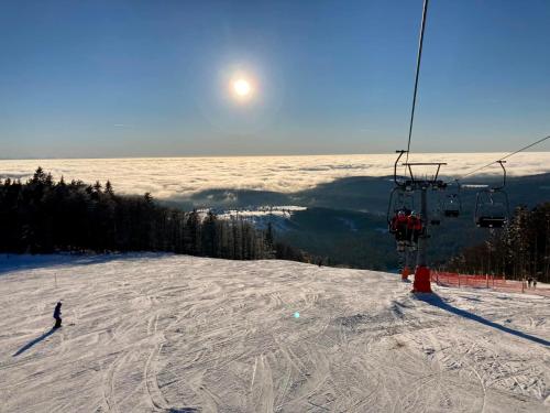 a person riding a ski lift on a snow covered slope at Aotearoa - Mountain apartment in Bavaria, Mitterdorf - Mitterfirmiansreut in Mitterfirmiansreut