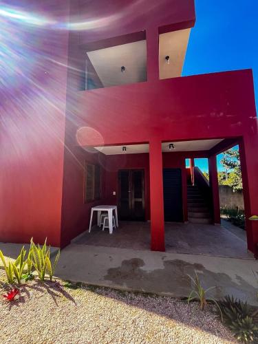 a red building with a white table in front of it at Mokambo da Serra in Alto Paraíso de Goiás