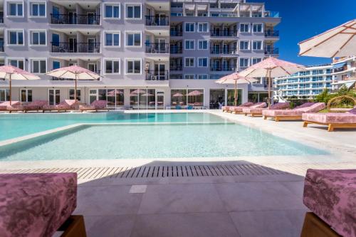 a swimming pool in front of a building at J'ADORE Secret Garden A&K Deluxe Studio in Sunny Beach