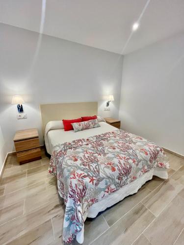 a bedroom with a bed with a red pillow at La Marina Apartamentos in O Grove