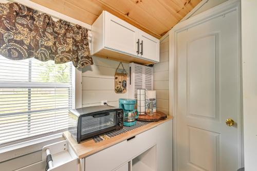 a tiny kitchen with a counter with a microwave and acomputer at 14 Mi to Kentucky Horse Park Creekside Cabin in Georgetown
