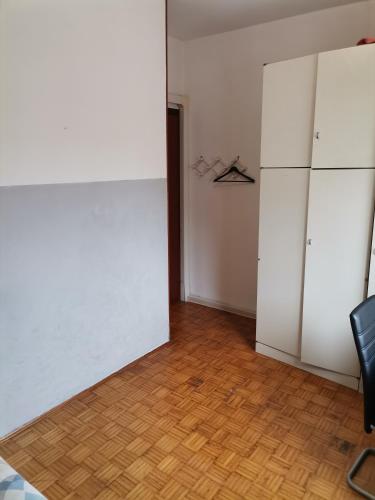 a room with a white refrigerator and a wooden floor at Apparemment in zona residenziale in Pordenone
