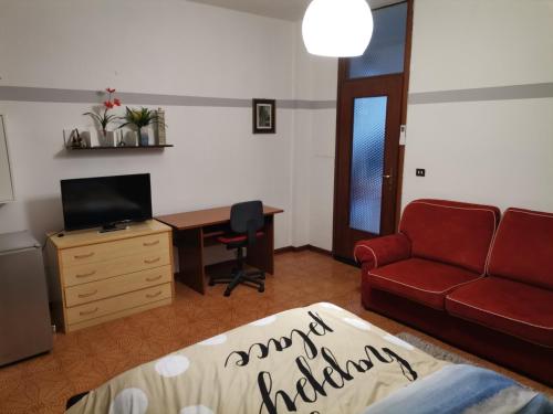 a living room with a red couch and a desk at Apparemment in zona residenziale in Pordenone