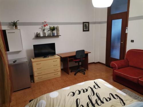 a living room with a desk and a red couch at Apparemment in zona residenziale in Pordenone