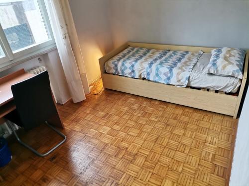 a bedroom with a bed and a desk and a window at Apparemment in zona residenziale in Pordenone
