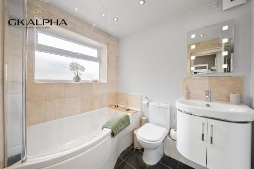 a bathroom with a tub and a toilet and a sink at Heartwarming Windsor Cottage with Free Parking - Perfect for Contractors, Relocators and Long Term Stays! Weekly And Monthly Stay Deals in Windsor
